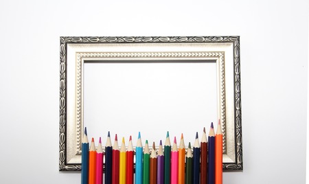 Vintage frame for paintings and colored pencils on a white background. Many colored pencils.の写真素材