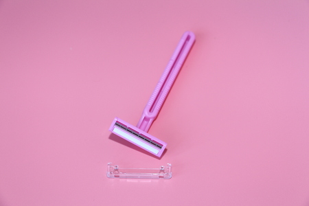 One razor is lying on a pink background. Pink razor on a pink background. Skin care.の写真素材