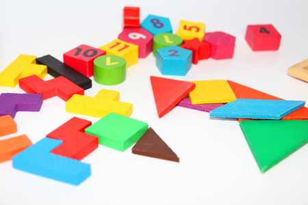 Multi-colored cubes and figures with numbers laid out randomly on a white background. Children learn to design from colored cubes. Wooden toys for children.の写真素材