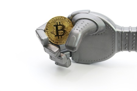 The robot holds one gold coin - bitcoin. White background. Cryptocurrency concept golden bitcoin. The concept of the intellectual mind.の写真素材