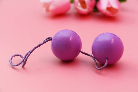 Pink vaginal balls on a pink background. Double vaginal balls. Womans health. Strengthening the intimate muscles of the vagina.の写真素材