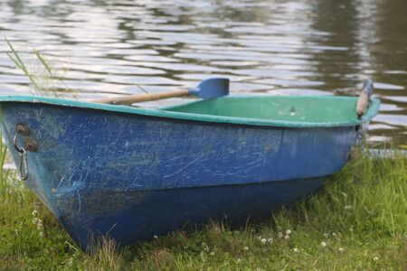 One boat on the lake. Empty fishing boat. Boat for riding tourists. Old wooden boat with a paddle.の写真素材
