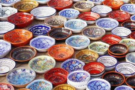 Tunisian tableware collection. The traditional pattern. Ceramic tableware. Multi-colored plates at the bazaar in Tunisia. Ceramic tableware market. Souvenir plates.の写真素材
