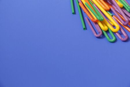 A lot of plastic tubules for drinks. Blue background. Close-up of straw tubes. Colorful trendy drinking straws, colored tubes for a party on a blue background.の写真素材