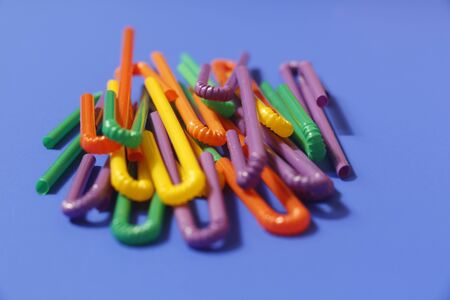 A lot of plastic tubules for drinks. Blue background. Close-up of straw tubes. Colorful trendy drinking straws, colored tubes for a party on a blue background.の写真素材