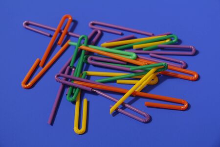 A lot of plastic tubules for drinks. Blue background. Close-up of straw tubes. Colorful trendy drinking straws, colored tubes for a party on a blue background.の写真素材