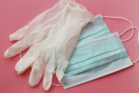 Two disposable medical masks and a pair of latex gloves. Medical kit of necessary disposable items....