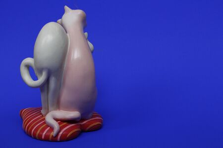 Two cats are hugging. Cats are close and love each other. Valentines Day. Figurine cats in love. Cats together are a symbol of lovers. Congratulation. Place for text. Blue color.の写真素材