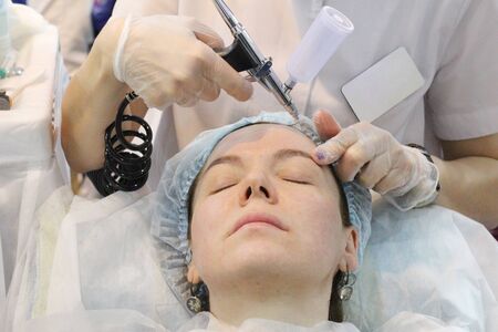 Moscow, RF, 04.19.2019. A cosmologist gives oxygen mesotherapy, oxygen therapy. The girl does anti-aging and medical procedures on her face. In a beauty salon.のeditorial素材