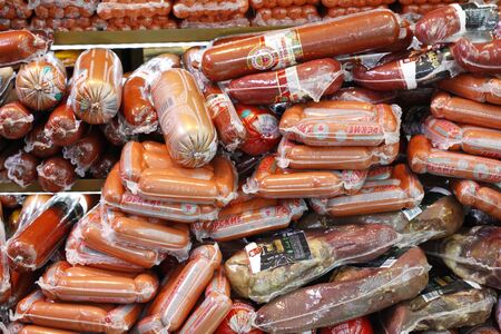 Moscow, RF. 02.10.2020: A lot of different sausages in the package. Appetizing sausages are in the refrigerator for storage. Tasty slices of smoked sausage are put up for sale in the market.のeditorial素材