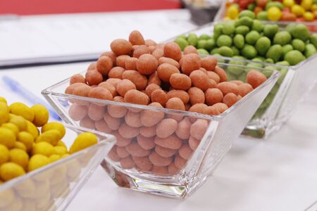 Peanuts in glaze curry, wasabi and chili. A selection of nuts on a table in a vase. Peanuts in...