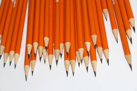 Many black lead pencils on a white background. Lead pencils. A lot of the same pointed pencils.の写真素材
