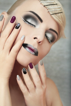 Makeup and manicure with grey shades and striped nail design.の写真素材