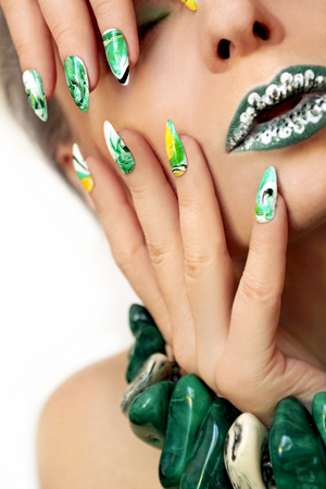Stone blurred water manicure white, yellow, green and black nail Polish on oval acute form.Nail art.の写真素材