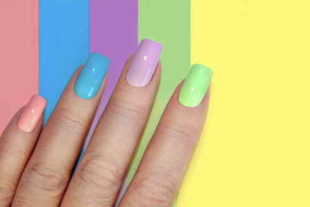 Multi-colored pastel manicure combined tone on tone with a striped background.Nail art.の写真素材