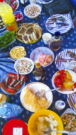 Variety of ready food in nature on a blue sea background.Summer feast on the sea theme.の写真素材