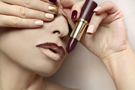 Multi-colored nail design. Burgundy nail polish and lip makeup. Glamorous plum Burgundy lipstick.の写真素材