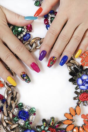 Creative bright saturated manicure on long nails with rhinestones. Nail art on women's hands on a...
