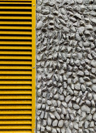 Modern ventilation design in the form of a window decorated with stone of various sizes and painted...
