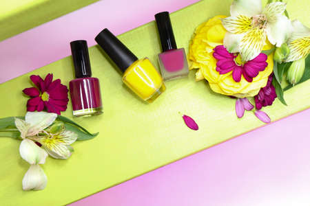 A set of three nail polishes in yellow, Burgundy, cherry glossy and matte colors with flowers.の写真素材
