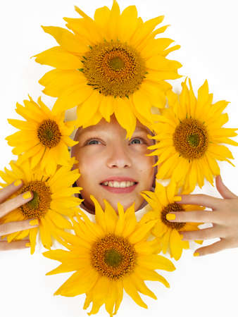 Portrait of a cheerful girl in yellow sunflowers around the face on a white background.の写真素材