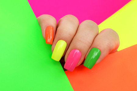 Bright illuminating multicolored fashionable manicure on a woman's hand.の写真素材