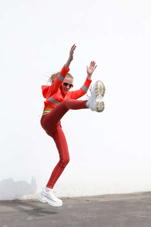 A girl jumps against the background of a wall in the city.の写真素材