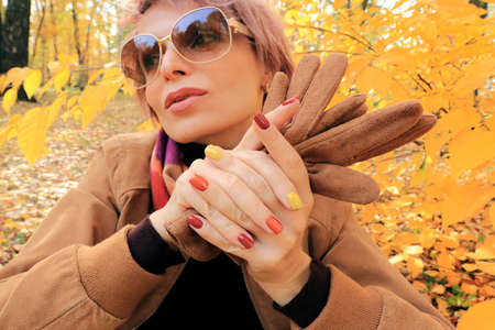 A model with accessories and a multi-colored manicure in autumn.の写真素材