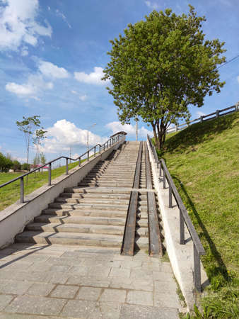 Summer landscape with a staircase leading to a road bridge.の写真素材