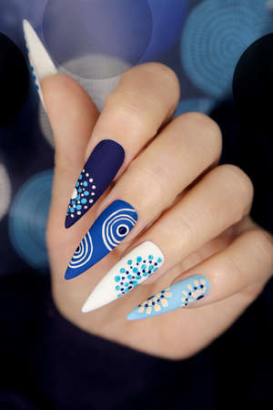 Multicolored blue nail art on a long sharp shape of nails.の写真素材