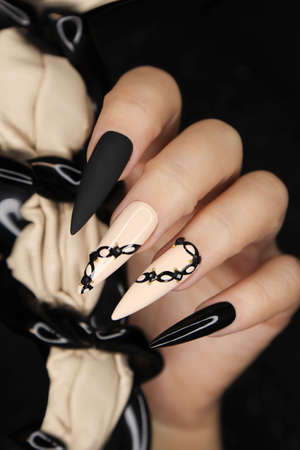 Beige and black manicure on long nails.の写真素材