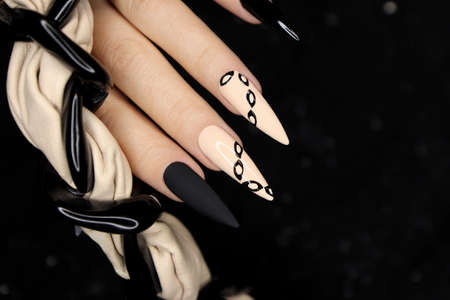 Beige and black manicure on long nails.の写真素材