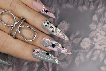 Design with pearls and rhinestones on the sharp shape of the nails.の写真素材