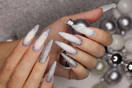 Manicure on long nails with silver glitter.の写真素材