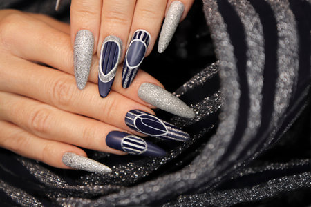 Manicure on long-shaped nails with blue and silver top coating.の写真素材
