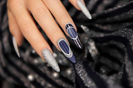 Manicure on long-shaped nails with blue and silver top coating.の写真素材
