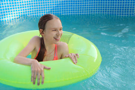 The girl happily swims in the pool.の写真素材