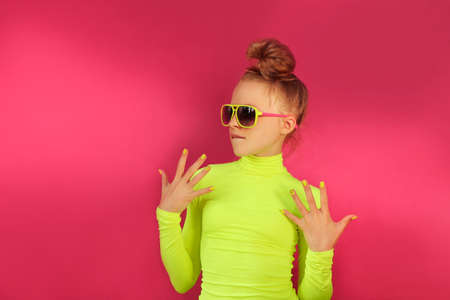A blonde girl poses in a yellow turtleneck and sunglasses.の写真素材