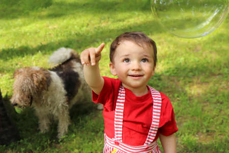 A child plays with soap bubbles in nature in summer.の写真素材