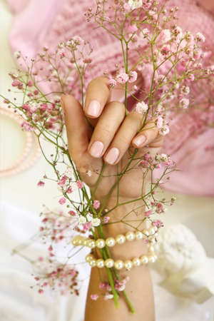 Light pink manicure on short nails with Gypsophila.の写真素材
