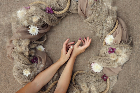 Decorative decoration with flowers on burlap with female hands.の写真素材