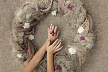 Decorative decoration with flowers on burlap with female hands.の写真素材