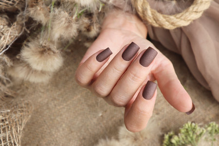 Female hand with brown nail design. Female hand with brown nail polish.の写真素材