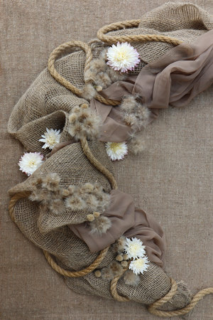 Brown scarf with white chrysanthemums on sackcloth backgroundの写真素材