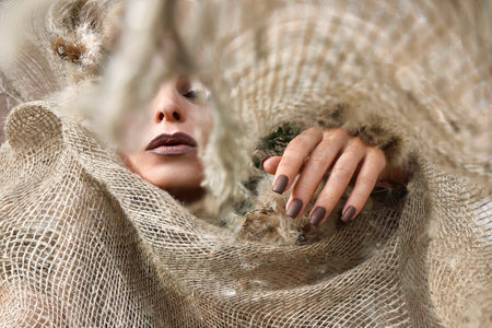 Young woman with long nails and manicure on natural background.の写真素材
