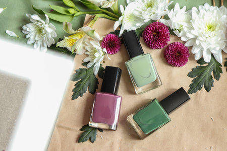 Nail polish bottles with flowers, top view. Flat lay.の写真素材