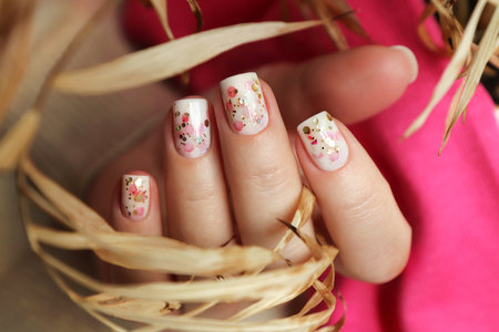 Nail design with golden and pink glitter on short nails.の写真素材