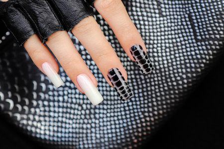 Nail design on long nails with milky white and black spreading effect on wet gel.の写真素材