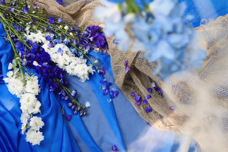 Floral arrangement on a blue background from a bouquet of colorful delphiniums with burlap.の写真素材