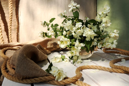 Floral arrangement of Jasmine on a linen background with burlap and rope.の写真素材